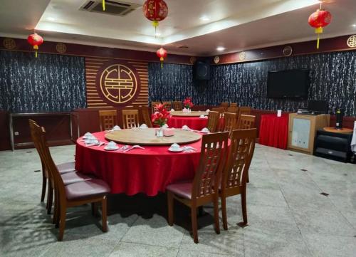 a dining room with a red table and chairs at Hotel Furaya in Pekanbaru