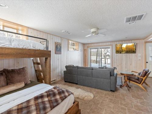 a bedroom with a bunk bed and a couch at Eagles Rest on Whitefish Chain in Pine River