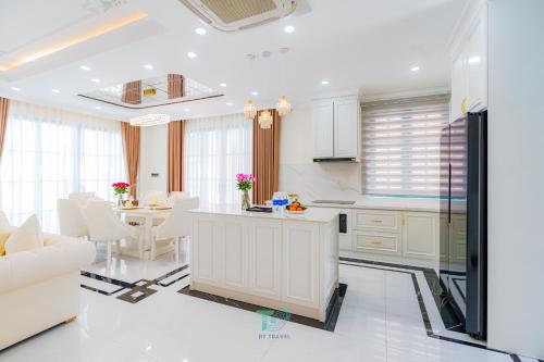 a kitchen with white cabinets and a table and chairs at DT Retreat - Biệt thự nguyên căn - 3 Phòng ngủ - Novaworld Phan Thiết in Phan Thiet
