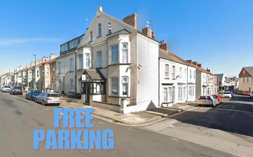 a row of houses on a street with the words free parking at OYO Tudor Lodge - Redcar Beach in Redcar