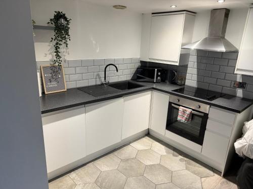 a kitchen with white cabinets and a stove top oven at 5 Halifax House Apartment 7 in Liverpool