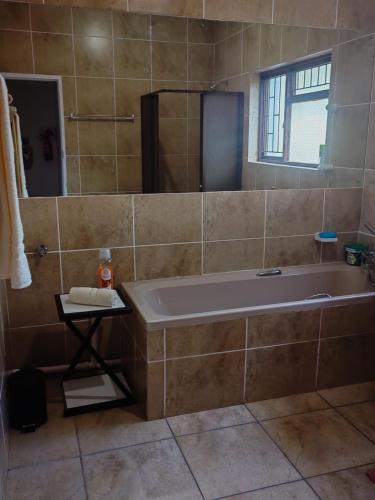 a large bathroom with a tub and a window at MayBach Hills Palace Guesthouse in Saldanha