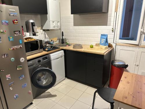 une cuisine avec un lave-linge et un réfrigérateur dans l'établissement Appartement muette, à Paris