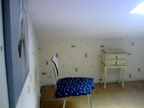 ルマンにあるシャンブル ドット リゲの青い椅子とテーブルが備わる客室です。