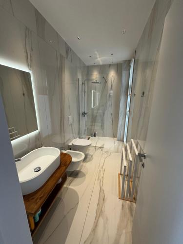 a white bathroom with two sinks and a shower at Villa Azul in Palasë
