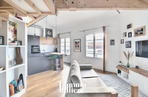 un salon avec un canapé et une cuisine dans l'établissement Appartement architecte proche plage, à Anglet