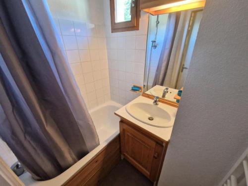 une salle de bain avec un lavabo et un rideau de douche dans l'établissement Les Chalets D'arrondaz - Vue exceptionnelle 3 pièces 4/6 personnes MAE-2938, à Modane