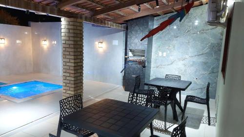 a patio with a table and chairs and a swimming pool at Casa temporada em Prado-BA ótimo preço in Prado