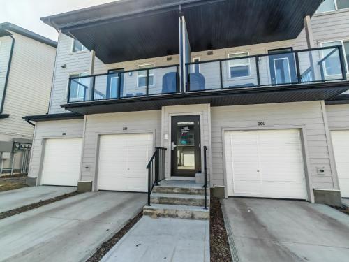 a house with two garage doors and a balcony at Sunlit Haven in Calgary