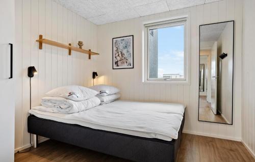 a bedroom with a bed with white sheets and a window at Nice Home In Højslev With Sauna in Højslev