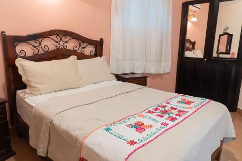 a bedroom with a bed with a blanket on it at Hotel Paraíso Encantado in Xilitla