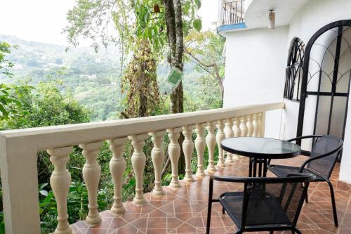 a balcony with a table and chairs and a view at Hotel Paraíso Encantado in Xilitla