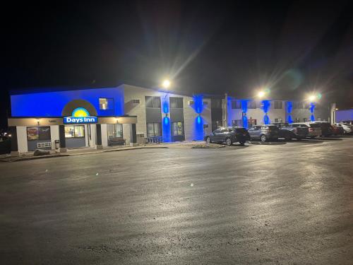 a gas station at night with cars parked in front at Days Inn by Wyndham Sioux Falls Airport in Sioux Falls