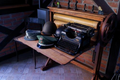 an old typewriter sitting on a wooden table with a hat at Hotel Huszcza in Mrągowo