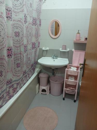 Un baño con lavabo y cortina de ducha. en Kannon, en Almada