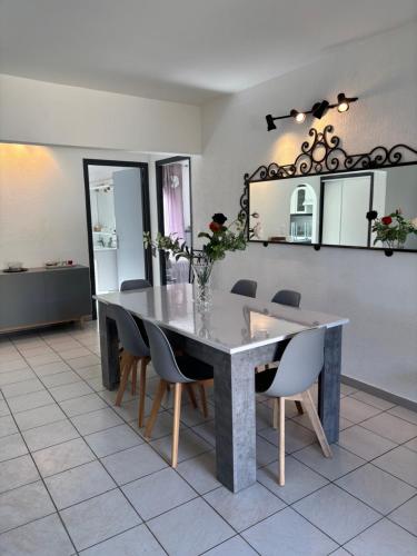 une salle à manger avec une table, des chaises et un miroir dans l'établissement Pietralba t3, à Ajaccio