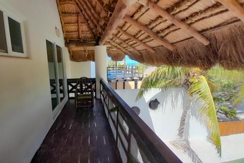 a balcony with a straw umbrella and a table and chairs at Hidra luxurious accommodation in San Benito