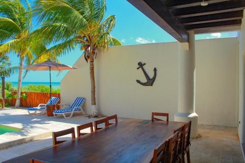 a dining room with a table and a palm tree at Hidra luxurious accommodation in San Benito