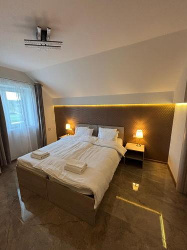 a bedroom with a large bed with two lamps on it at La Mirage in Šabac