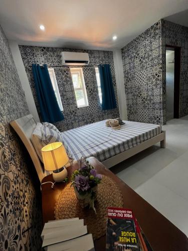 a bedroom with a bed with blue curtains at Villa Talisay - Beach house in Samal