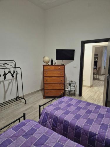 a bedroom with a purple bed and a dresser at Residenza La Torre in Foggia
