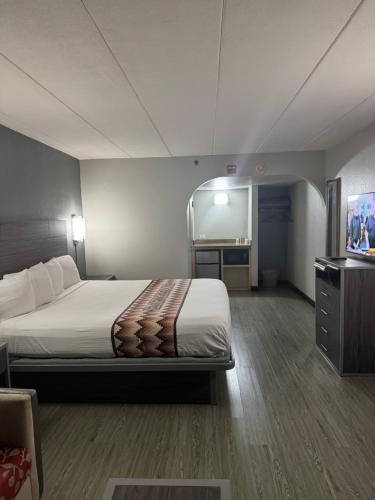 a hotel room with a bed and a tv at Blue Star Motel in Chicago Ridge