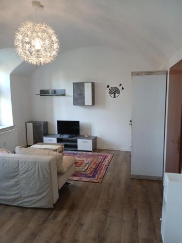 a living room with a couch and a chandelier at Zum Ritter Ferienwohnung 500 Meter zum Freizeitpark Plohn in Lengenfeld