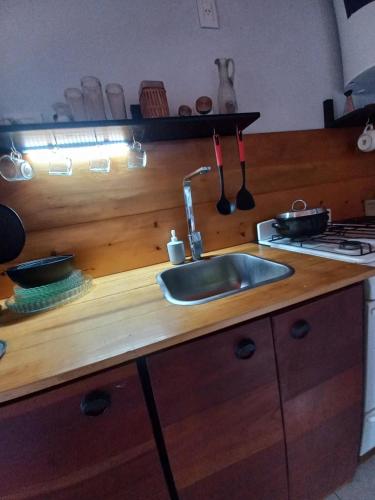 Una encimera de cocina con un fregadero y una estufa. en La Obra Vintage, en Ciudad Evita