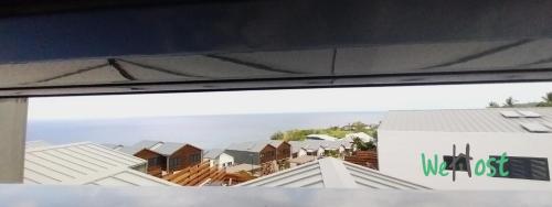 a view of a bunch of houses from a window at "Villa Maria" - Sublime vue Océan Classée 4 étoiles in Petite Île