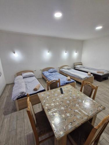 a room with three beds and a table and chairs at Konak Kod Gorana 1 in Subotica