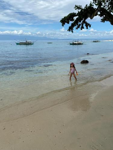 a young girl playing in the water on the beach at Villa Talisay Ocean View in Samal