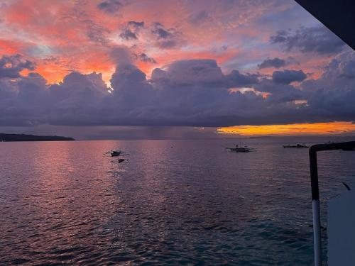 a sunset over the ocean with boats in the water at Villa Talisay Ocean View in Samal