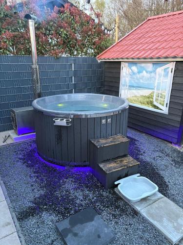 a hot tub and a toilet in a yard at Wellness chalet Putten Hottub & Sauna in het bos in Putten