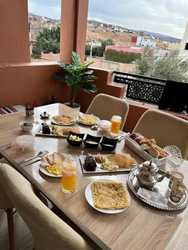 a table full of food and drinks on a balcony at Mountain Taghazout Apartment in Taghazout