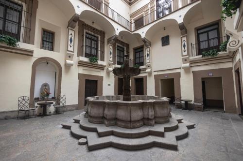 a courtyard with a fountain in the middle of a building at Hotel Gala in Puebla