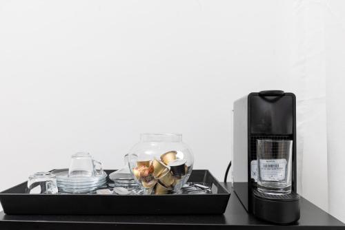 a tray with dishes and a coffee maker on a table at Beach Vibe Villa - Sunny Stay in O Ben Slimane