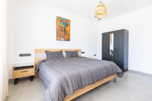 a bedroom with a large bed and a night stand at Beach Vibe Villa - Sunny Stay in O Ben Slimane