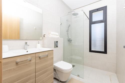 a bathroom with a toilet and a sink and a shower at Beach Vibe Villa - Sunny Stay in O Ben Slimane