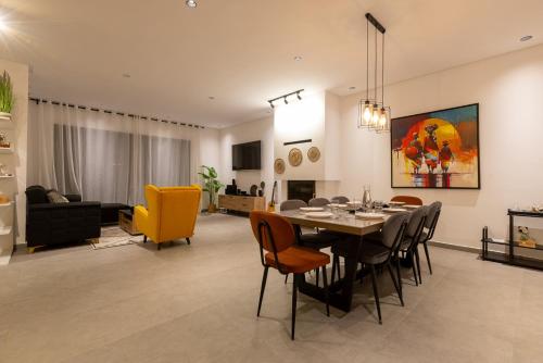 a dining room and living room with a table and chairs at Beach Vibe Villa - Sunny Stay in O Ben Slimane