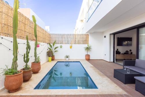 an indoor swimming pool in a house with plants at Beach Vibe Villa - Sunny Stay in O Ben Slimane