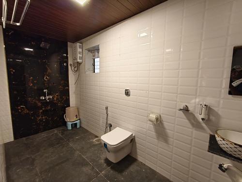 a bathroom with a toilet and a sink at The Mango Valley Nature's Stay in Alibag