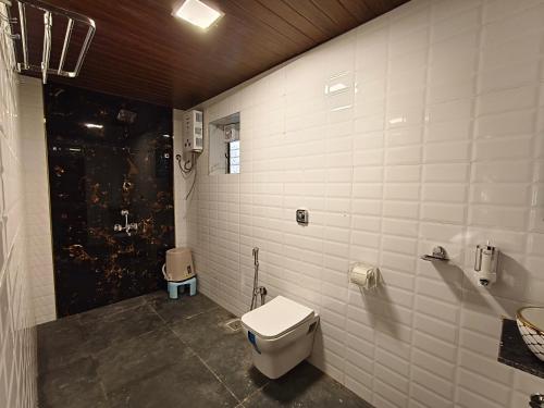 a bathroom with a toilet and a sink at The Mango Valley Nature's Stay in Alibag
