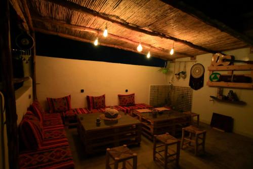 a living room with a couch and a table and chairs at Jurassic Surf House Anza in Agadir