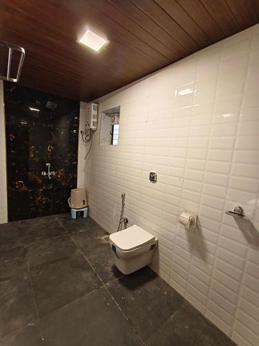 a bathroom with a toilet in a room at The Mango Valley Nature's Stay in Alibag
