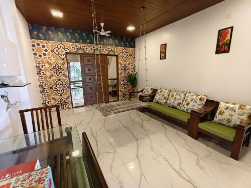 a living room with a couch and a marble floor at The Mango Valley Nature's Stay in Alibag