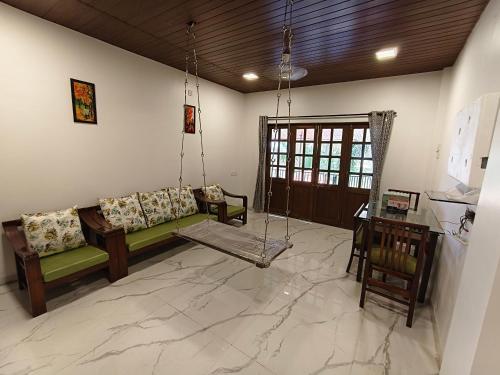 a living room with a couch and a swing at The Mango Valley Nature's Stay in Alibag