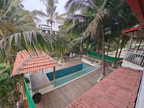 an overhead view of a swimming pool with palm trees at The Mango Valley Nature's Stay in Alibag