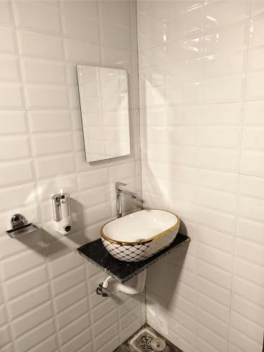 a bathroom with a sink and a mirror on a counter at The Mango Valley Nature's Stay in Alibag