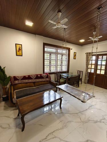 a living room with a couch and a table at The Mango Valley Nature's Stay in Alibag