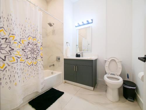 a bathroom with a toilet and a shower curtain at New Modern 2BR Apartment - minutes to NYC in Bayonne